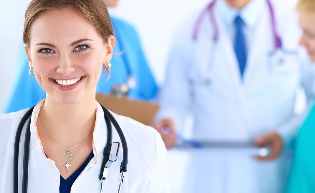 Smiling female healthcare professional with stethoscope around her neck