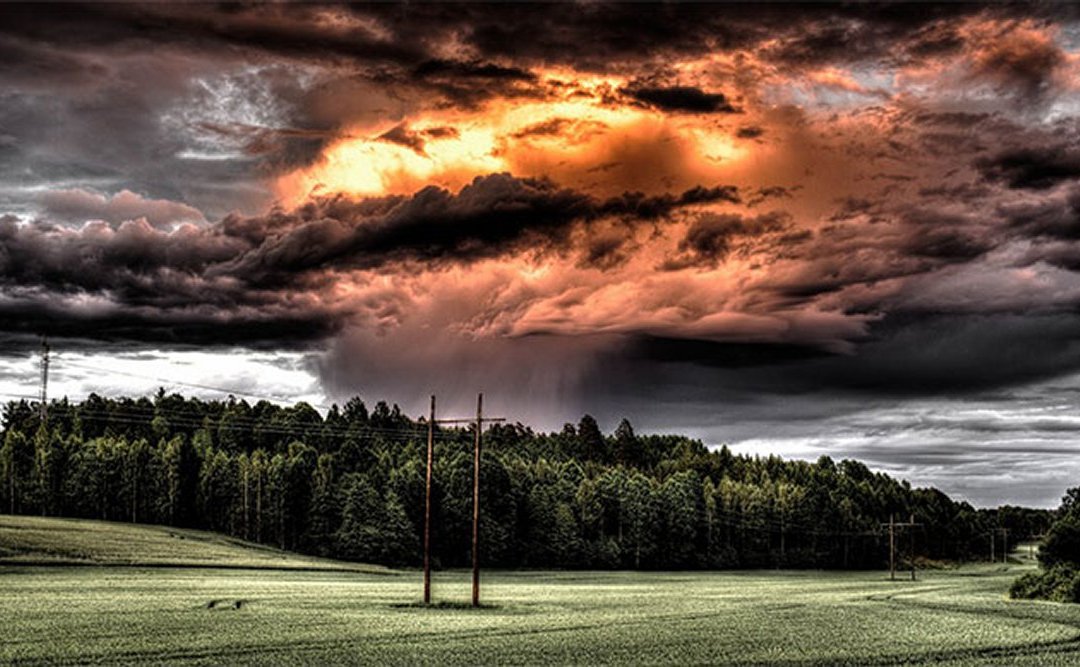 Angry sky, impending storm over lush green field