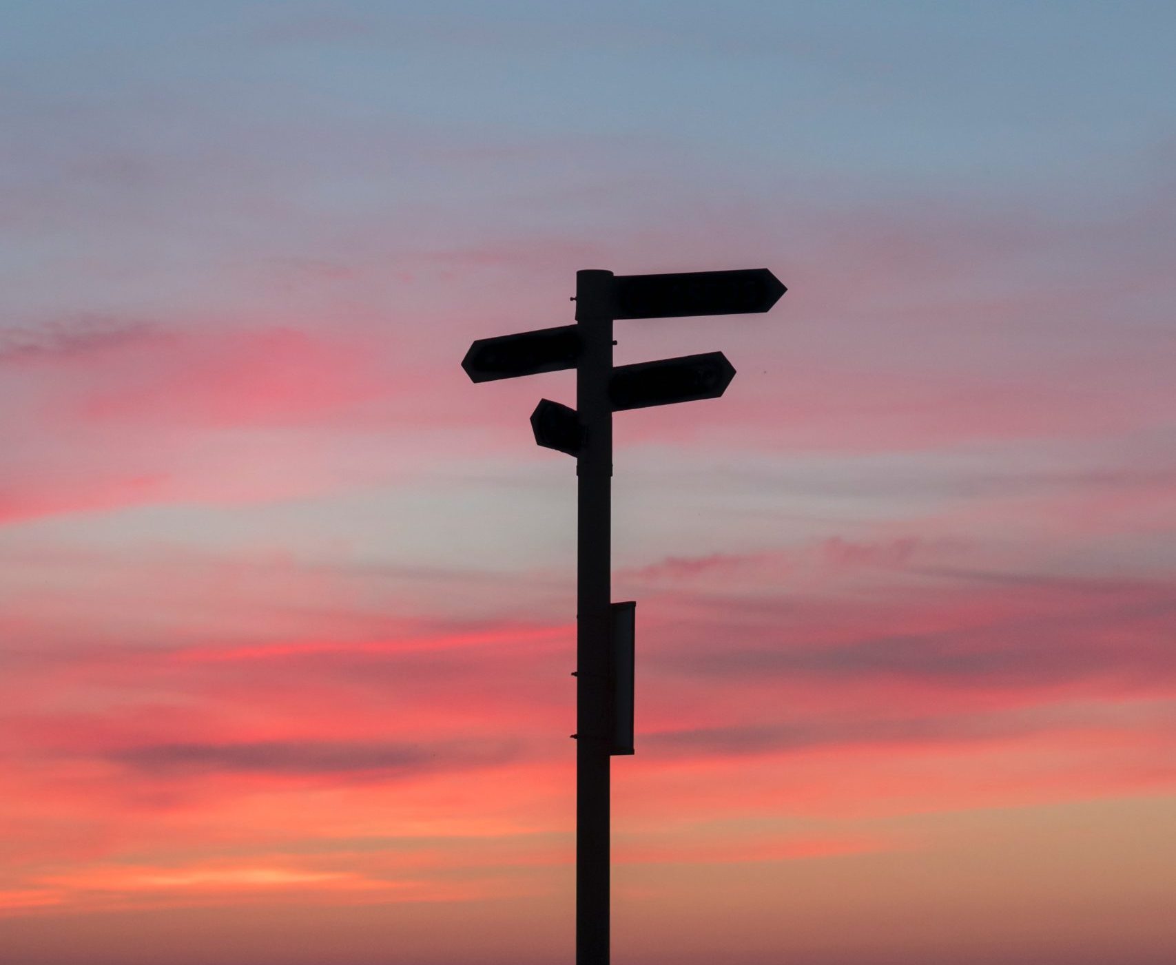silhouette of directional sign on sunset