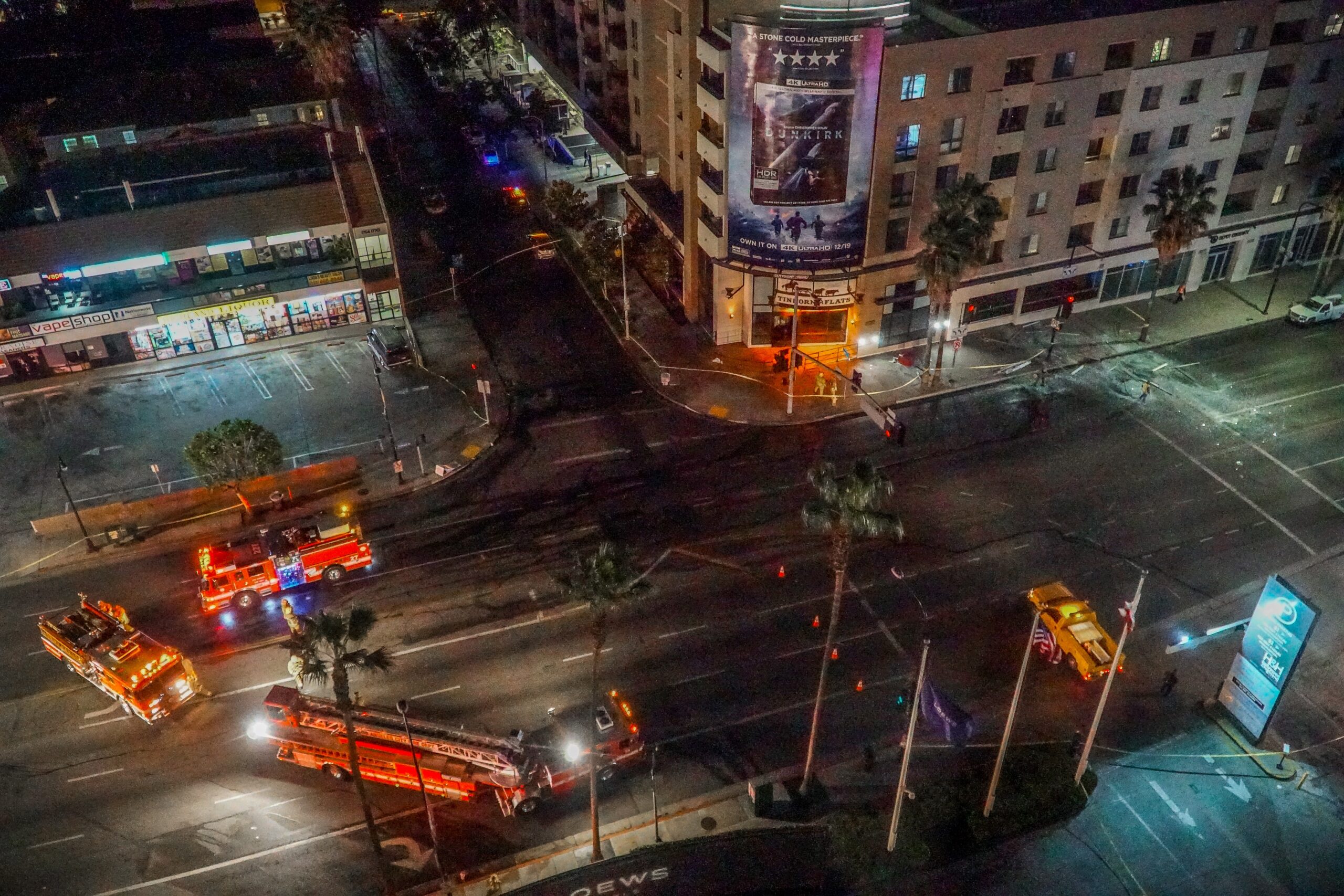 Emergency vehicles surrounding buildings at night